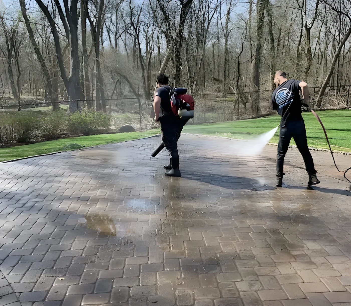 WeatherX technicians power washing a paver driveway