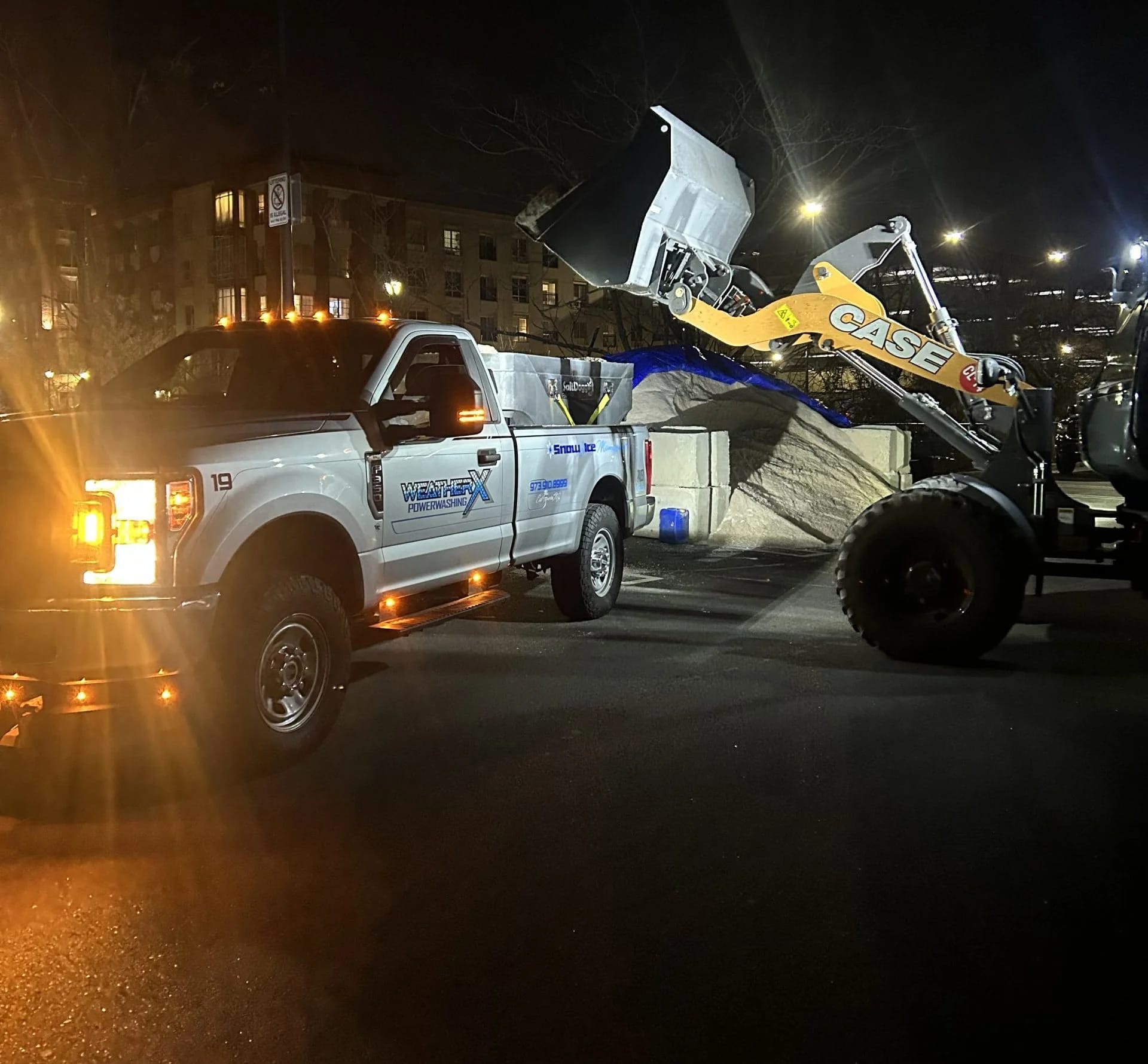 WeatherX plow truck clearing a commercial lot at night